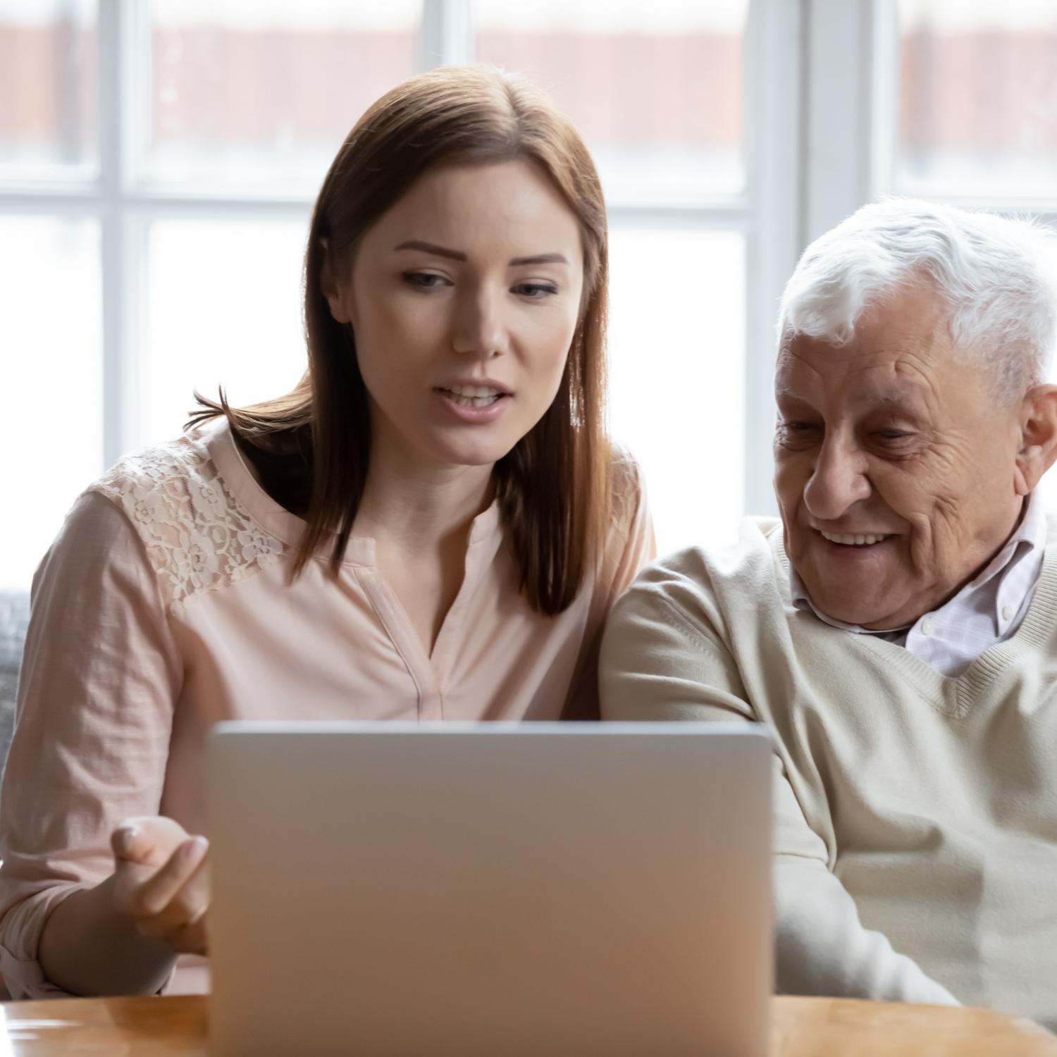 Alter Mann und junge Frau am Laptop