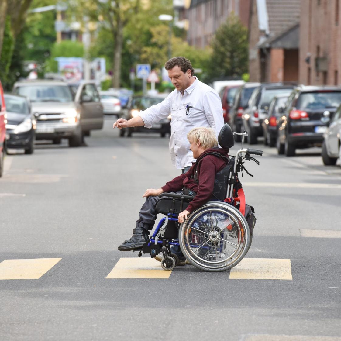 Rollstuhlfahrer auf Zebrastreifen